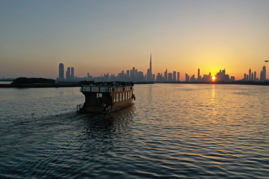 Dubai Creek sunset with dhow and Burj Khalifa